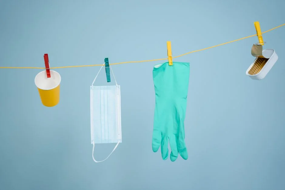 Anonymous person in yellow rubber gloves using simple sponge for cleaning mirror in bathroom